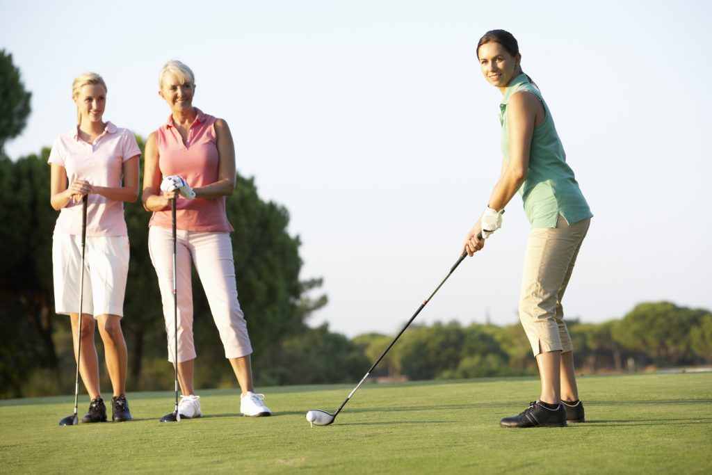 Frauengruppe beim Golf spielen auf dem Golfplatz