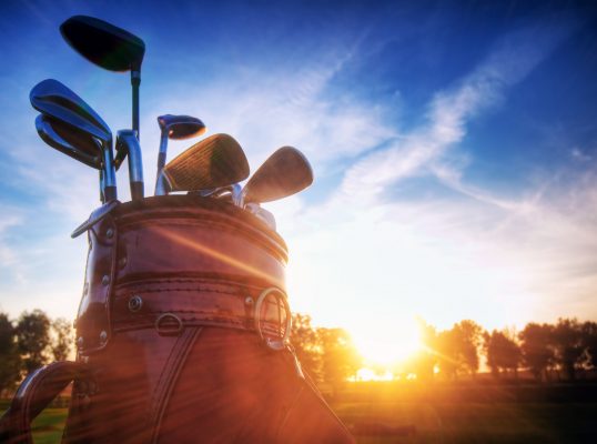 Professional golf gear on the golf field at sunset.